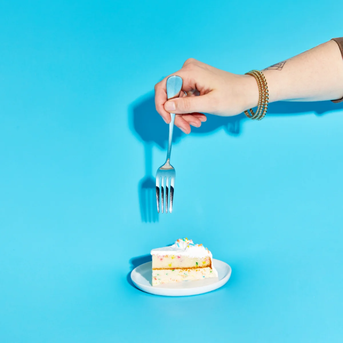 Hand with fork and ice cream cake