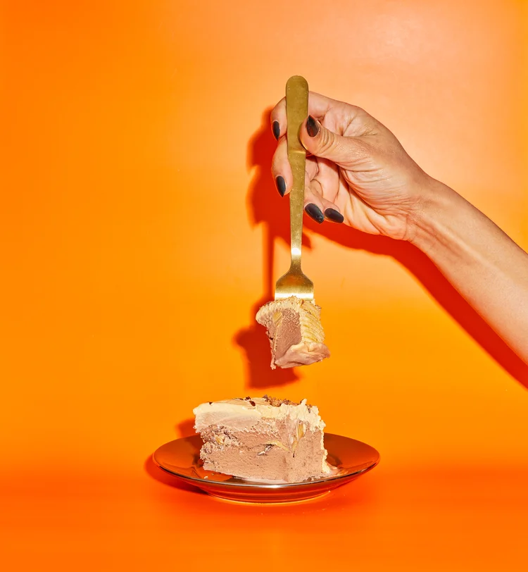 Hand with fork and ice cream cake
