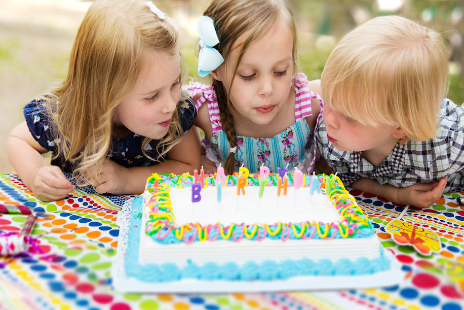 Children blowing candles on a cake out
